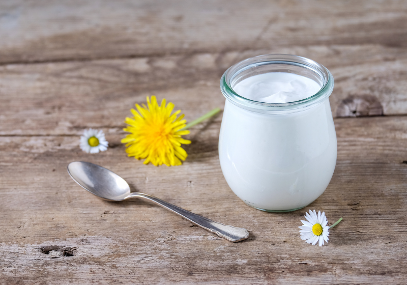 joghurt im glas mit löffel und blumen
